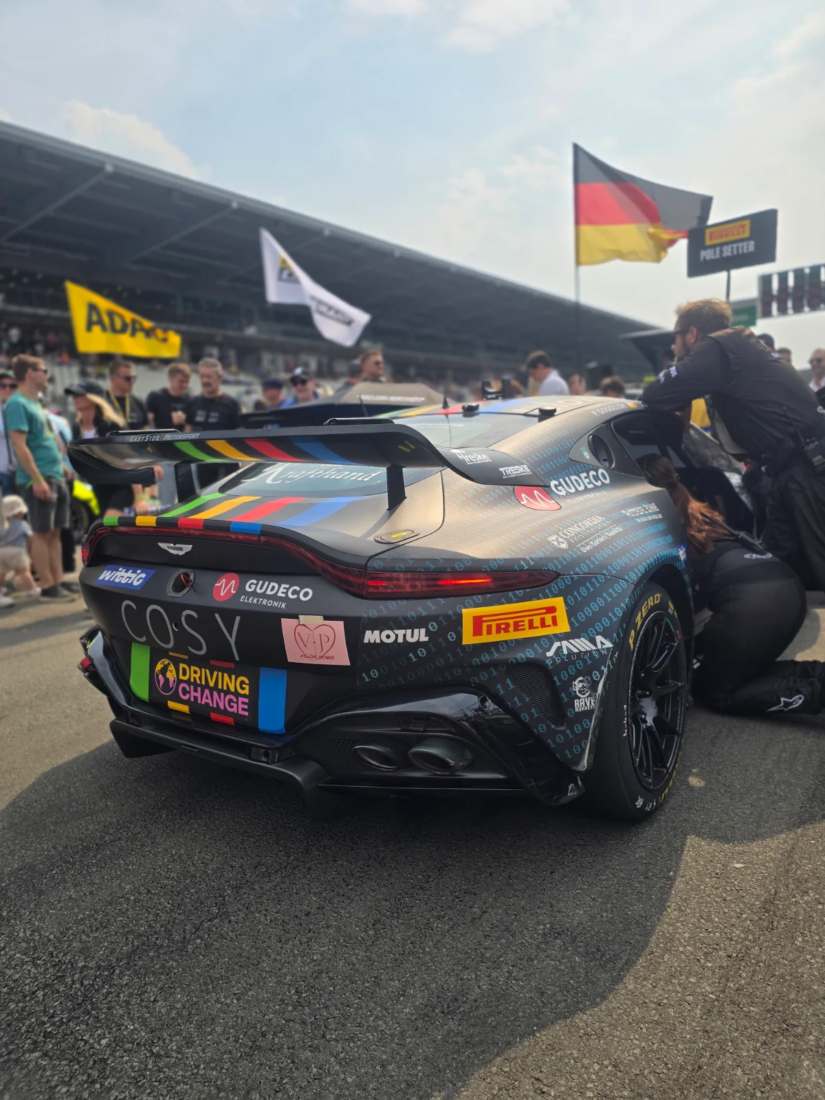Heck des Aston Martin Vantage GT4 von EastSide Motorsport in Binär-Code-Livery, mit SAMD-Logo über dem Hinterrad